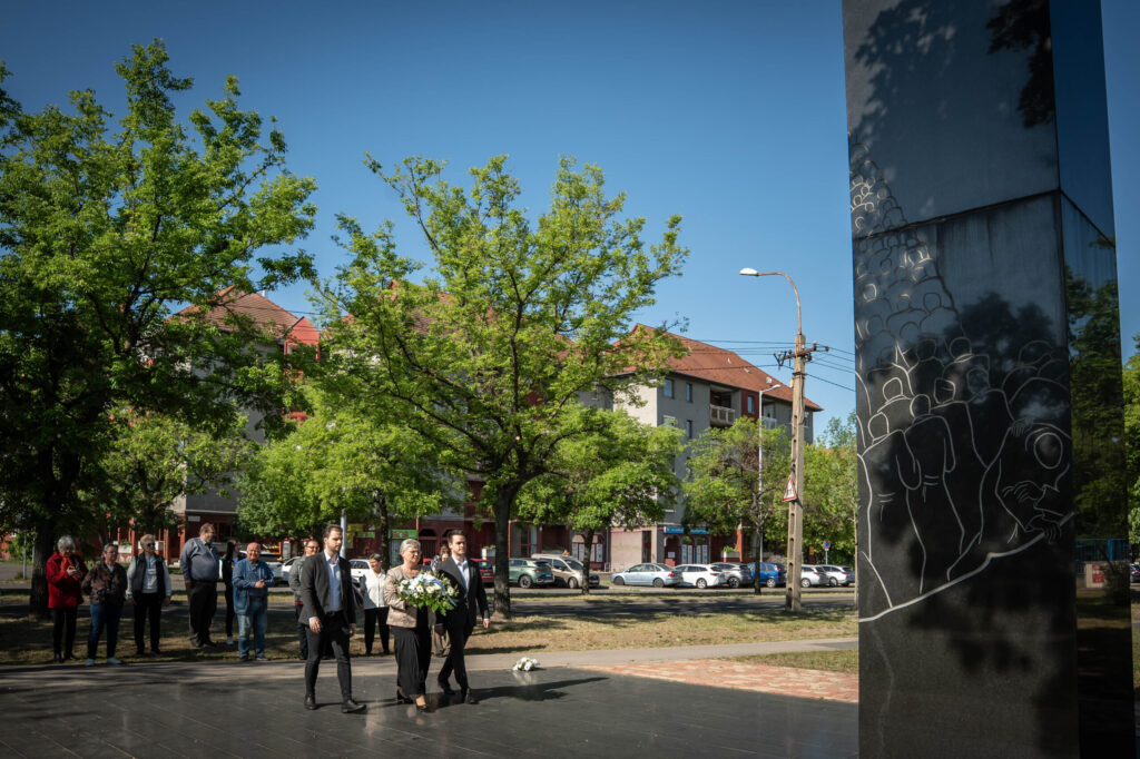 Európa‑napi megemlékezés Rákospalotán. A kerület vezetősége koszorút helyez el a fekete emlékműnél, miközben a résztvevők csendben figyelik a ceremóniát.