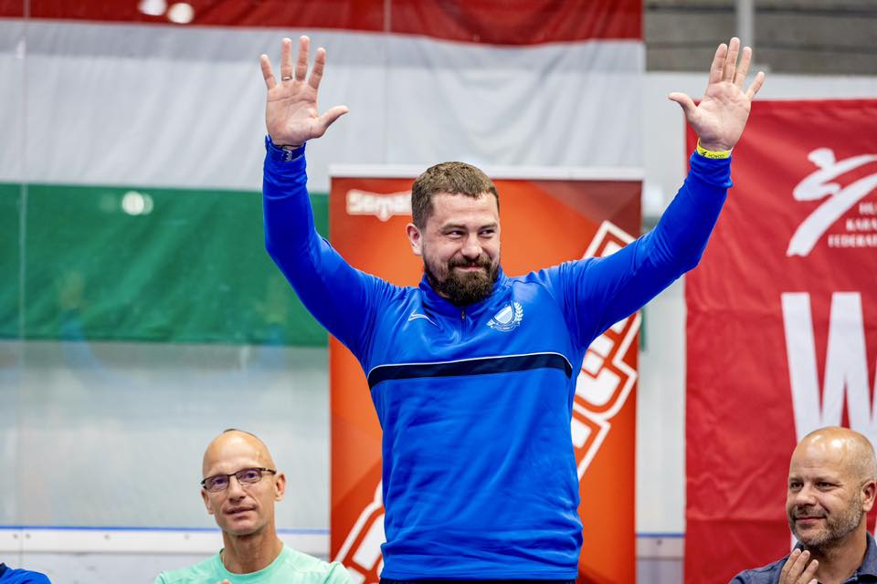 Hárspataki Gábor az UTE Jégcsarnokban két kézzel integetve búcsúzik az élsporttól, mellette bal oldalon edzője, Fischer Mihály áll.