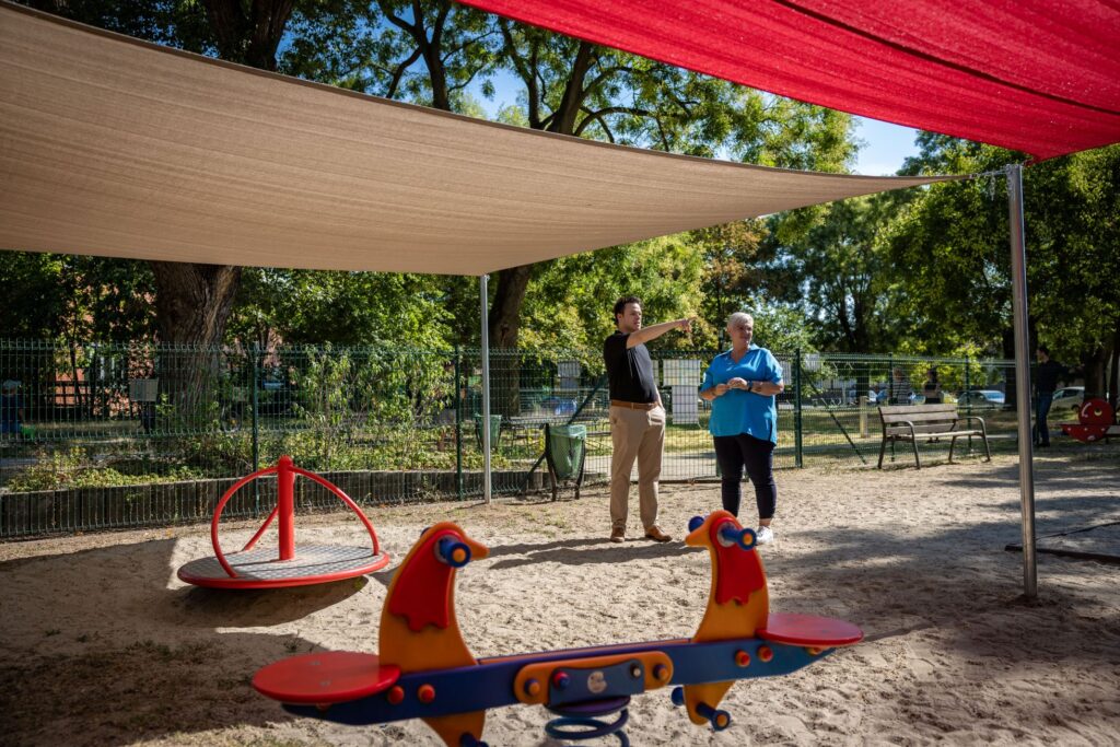 Cserdiné Németh Angéla polgármester és Csernák János alpolgármester megtekinti az Őrjárat utcai játszótéren megvalósított árnyékolási fejlesztést.