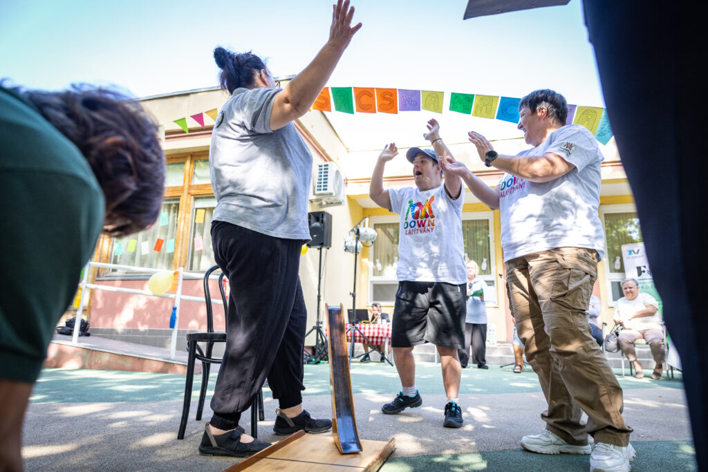 Egy jól sikerült gurítás után közös öröm a pálya mellett. A speciális bowling több mint két évtizede teremt élményt és sikerélményt a résztvevők számára.