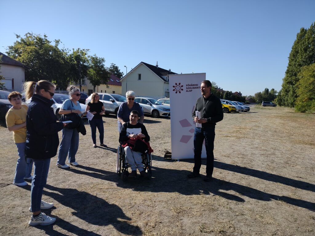 Az alapítvány Pöstyén utcai sajtótájékoztatóján mutatták be a tervezett lakóotthon helyszínét. A képen középen Schilling Magdolna látható kerekesszékben ülő fiával, körülöttük a beruházást támogató és bemutató résztvevők.