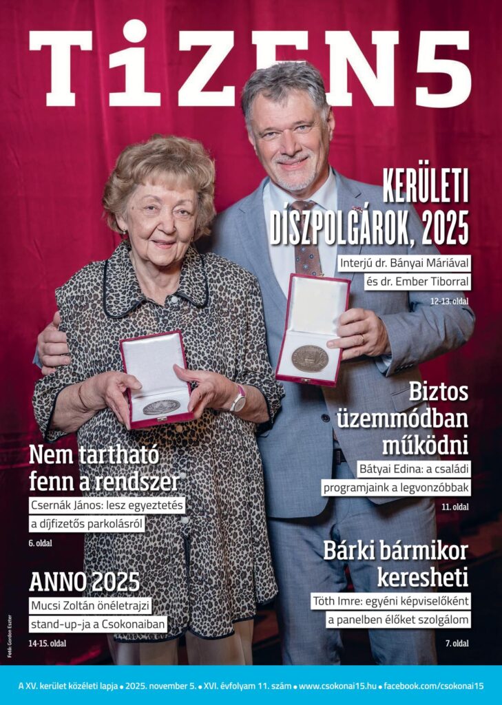 Címlap, a belső tartalmat ajánló feliratokkal. A képen egy idősebb hölgy és egy középkorú, öltönyös férfi áll. Mindketten nyitott díszdobozt tartanak a kezükben, benne érme.